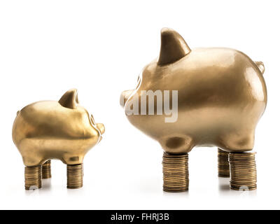 Deux grands et petits golden piggybanks debout en face de l'autre sur des pieux d'argent sur fond blanc Banque D'Images