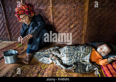 Vieille Femme et enfant endormi avec thanaka coller face à des tribus des Pa-O ou Pa-Oh ou Pao ou Noir Karen ou Taungthu ou Banque D'Images