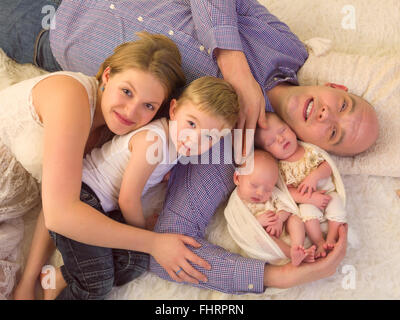 Heureux les parents qui posent avec leur nouveau-né jumeaux identiques et tout-petit frère Banque D'Images