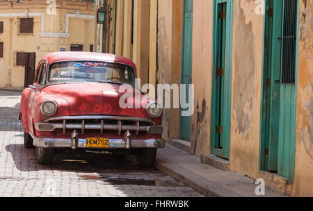 Vieille voiture rouge garée sur rue avec des bâtiments à La Havane, Cuba, Antilles, Caraïbes, Amérique Centrale - Scène de rue avec vintage car Banque D'Images