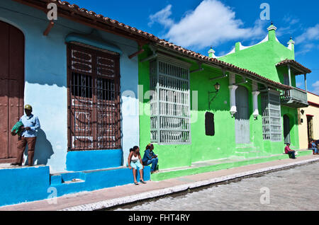 Les gens assis devant les maisons, la Plaza San Juan de Dios, Camagüey, Cuba Banque D'Images