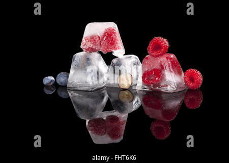 Les petits fruits congelés dans des cubes de glace. Banque D'Images