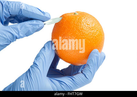 Scalpel et orange dans les mains du médecin Banque D'Images