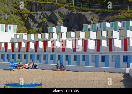 Cabines de plage à la plage Tolcarne beach à Newquay, Cornwall, Angleterre. Avec les gens sur la plage Banque D'Images