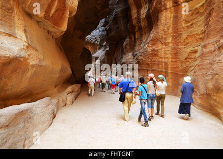 Petra, Jordanie : Groupe de touristes marchant dans la Siq pour rejoindre la ville de Petra. Petra est l'une des sept merveilles du monde Banque D'Images