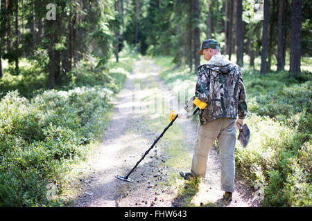 Chasseur de trésor avec détecteur de métal et une pelle en forêt Banque D'Images