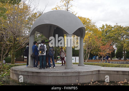 Les élèves sonner la cloche de la paix à Hiroshima Peace Memorial Park, Japon Banque D'Images