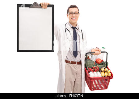 Jeune médecin tenant un panier plein de provisions et un presse-papiers isolé sur fond blanc Banque D'Images