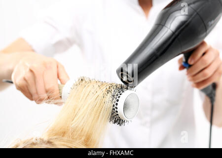 Peigner les cheveux brosse de séchage. La femme à la coiffure, modèles coiffure cheveux sur une brosse ronde. Coiffure cheveux secs Banque D'Images