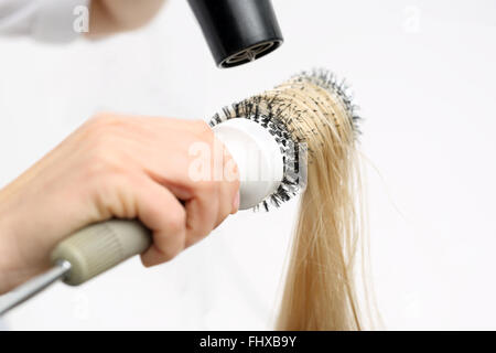 Peigner les cheveux brosse de séchage. La femme à la coiffure, modèles coiffure cheveux sur une brosse ronde. Coiffure cheveux secs Banque D'Images