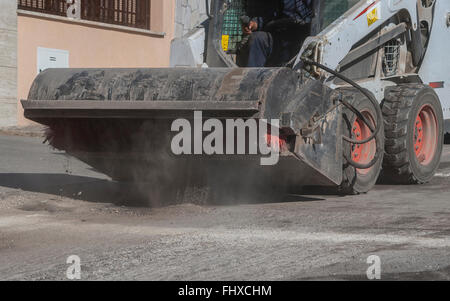 Sweeper mini pelle pièces jointes. La balayeuse balaie, recueille et déverse la saleté et les débris. Banque D'Images