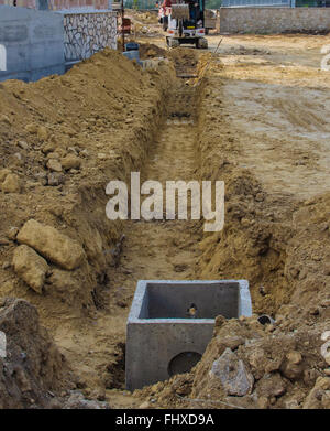 Le racloir pour travailler l'ensemble d'un chantier lors de l'excavation pour la pose de conduites d'eau Banque D'Images