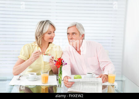 Senior couple at table du petit déjeuner avec café et lire la presse Banque D'Images