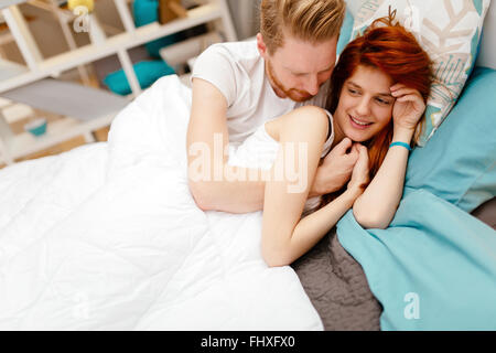 Beautiful couple in love awake in bed and smiling Banque D'Images