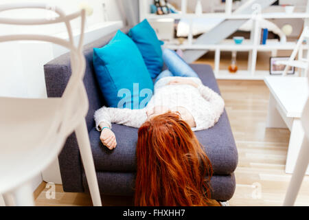 Belle femme allongée sur un canapé dans une belle salle de séjour Banque D'Images