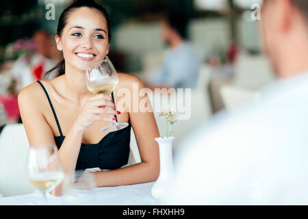 Couples célébrant dans le restaurant et prendre un verre de vin blanc Banque D'Images