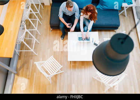 Couple browsing web dans son ensemble dans la salle de séjour vue d'en haut Banque D'Images