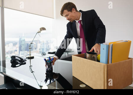 Businessman a récemment embauché pour l'entreprise Offres d'emménage dans son nouveau bureau exécutif avec vue sur la ville. Banque D'Images