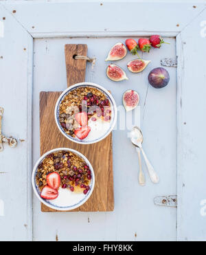 Petit-déjeuner sain. Bols de céréales d'avoine avec du yogourt fraises figs grenadier et miel sur sanglier en bois rustique Banque D'Images