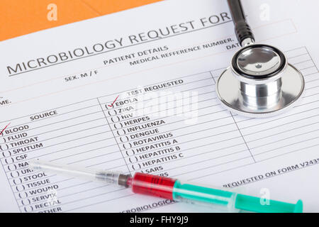 Test sanguin microbiologiques indiquant un résultat de test positif pour le virus Ebola sur un bureau de médecins avec un stéthoscope Banque D'Images