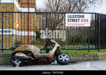 Burnt Out cyclomoteur. Moto à côté de clôture à Westminster, Londres, après avoir été mis le feu dans un acte présumé de l'incendie criminel Banque D'Images