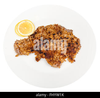Vue du dessus de l'escalope de veau poêlé et des rondelles de citron sur l'assiette blanche isolé sur fond blanc Banque D'Images