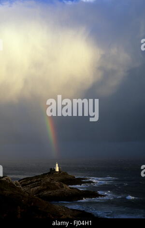 Il y a de la lumière à la fin de l'Arc en Ciel. Un arc-en-ciel tombe des nuages dans un arbre de lumière à Mumbles Swansea Bay,Light House, lieu où des Lagoon Banque D'Images