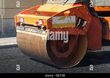 Fragment de rouleau orange, urbains, routiers est en cours de construction, de l'asphaltage en cours Banque D'Images