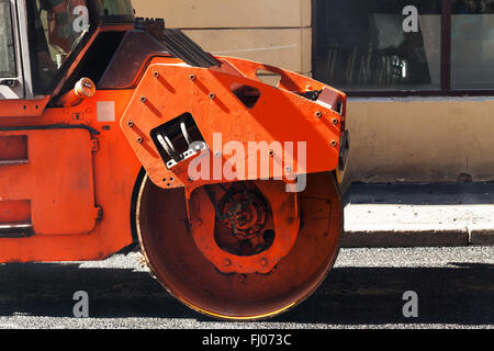 Fragment de rouleau orange, urbains, routiers est en cours de construction, de l'asphaltage en cours Banque D'Images