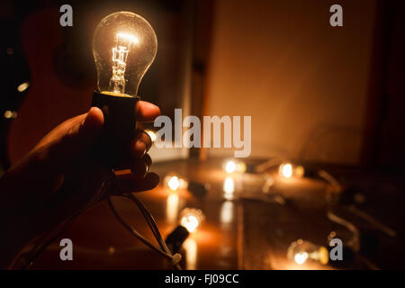 Lampe à incandescence, chaud sous tension. Guirlande de lampes tungstène. La lumière dans l'obscurité, l'espace de copie. Banque D'Images