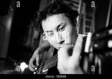 Guitariste passionné fou à jouer de la guitare, noir et blanc portrait en gros. Musicien aux cheveux ébouriffés. Banque D'Images