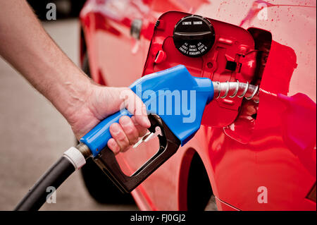 L'essence bleu buse en voiture rouge Banque D'Images