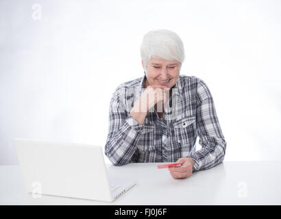 Femme âgée travaillant avec ordinateur portable et carte de crédit (banque) Banque D'Images