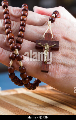 Close up of a woman's hands holding rosary a porté sur la croix Banque D'Images