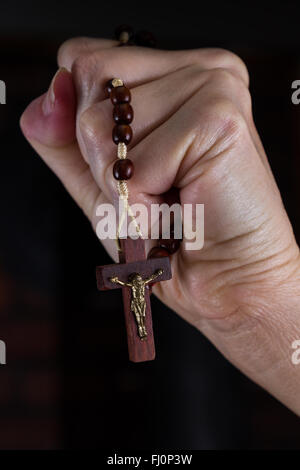 Close up of a woman's hands holding rosary a porté sur la croix Banque D'Images