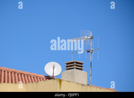Antennes et cheminée sur un toit italien Banque D'Images