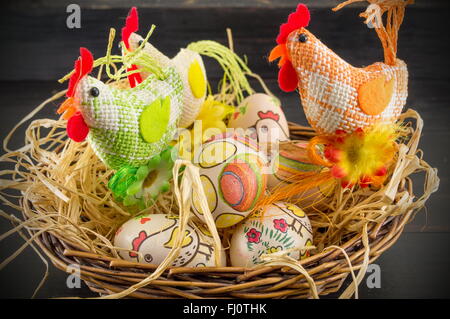 Oeufs de Pâques décorés de découpage et de la famille de toy poulets dans un nid Banque D'Images