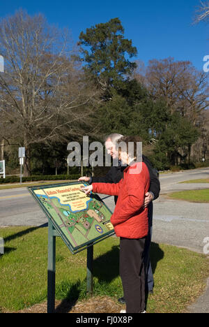 Couple caucasien lisant un panneau directionnel à Edisto Memorial Gardens, Orangeburg, Caroline du Sud, États-Unis. Banque D'Images