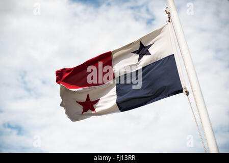 Canal de Panama Drapeau panaméen Ville de Panama | CANAL DE PANAMA, Panama — Le drapeau national panaméen flotte contre un ciel nuageux au-dessus du canal de Panama, la voie navigable d'environ 50 miles (80 km) qui relie l'océan Atlantique et l'océan Pacifique à travers l'isthme de Panama. Les États-Unis ont construit et exploité le canal de 1904 jusqu'à ce qu'ils en transférent le contrôle total à Panama le 31 décembre 1999, en vertu des traités Torrijos-Carter de 1977. Banque D'Images