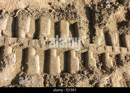 Arrière-plan avec des traces de pas dans le sable de machinerie lourde Banque D'Images