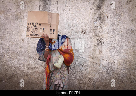 Une femme mendiant dans les rues de Harar est cachant son visage avec un morceau de carton et portant son bébé endormi , Éthiopie Banque D'Images