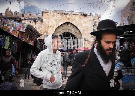 L'homme arabe et juif ultra-orthodoxe traditionnelle homme Haredim sont à pied togehter près de la porte de Damas, Jérusalem, Israël Banque D'Images