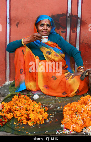 Femme vente de fleurs et de boire du thé à Jaipur, Inde Banque D'Images