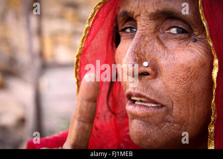 Woman with red saree Rajasthani et anneau pour le nez montre un doigt à l'appareil photo avec une forte expression sur son visage , Jaisalmer , Inde Banque D'Images