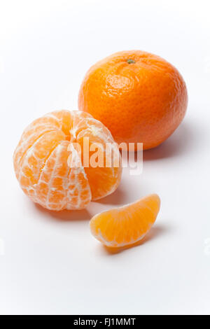 La mandarine fraîche, pelée et avec une coupe sur fond blanc Banque D'Images