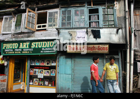 Deux hommes marchent ensemble main dans la main dans une rue de Shimla , Inde Banque D'Images