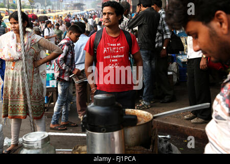 L'homme ayant des t shirt dans la foule au petit matin en face de la gare de Howrah, Kolkata , Inde Banque D'Images