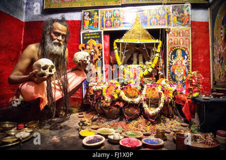 Portrait d'Aghori sadhu cannibale saint homme en face de temple décoré à Varanasi, Inde Banque D'Images