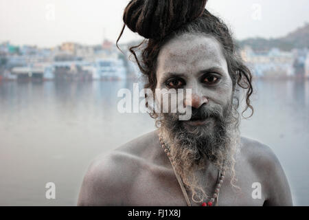 Naga sadhu saint homme devant le lac sacré de Pushkar, Rajasthan Banque D'Images