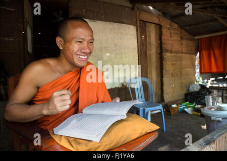 Le moine bouddhiste reading book in monastère à Phnom Penh, Cambodge Banque D'Images